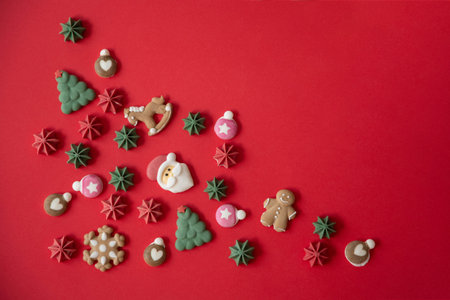 Confectionery decoration on the theme of Christmas and New Year in the form of a Santa Claus and a Christmas tree are on a red background. Copy space.の写真素材