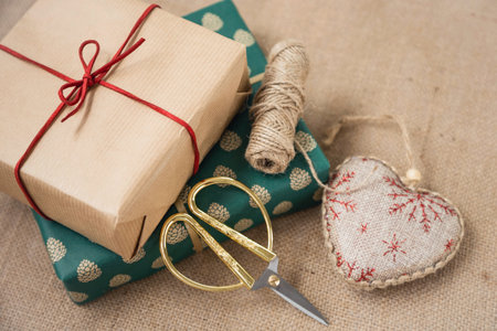 Gifts packed in paper, rope and scissors are on the table. Preparation for Christmas.の写真素材
