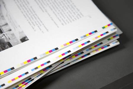 White sheets with with the text and paint around the edges are stacked in a printing house. An...