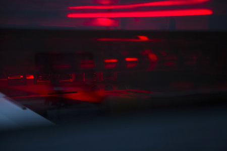 Close-up printing machine illuminated with red light. Abstract image of printing equipment.