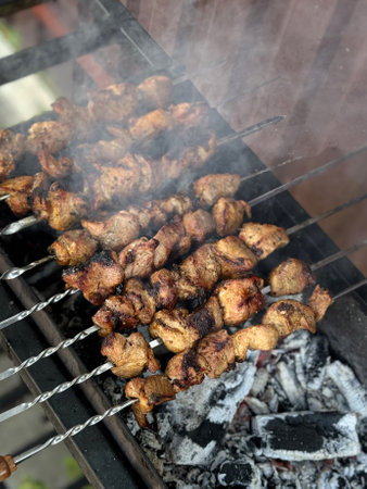 Shish kebab on metal skewers over the coals.