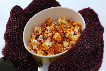 Young woman holding popcorn in winterの写真素材