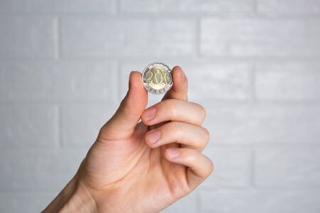 Hold the tenge coin in your hand. Close up. New Kazakhstan coin 200 tenge. Money, Bank, save, spend.