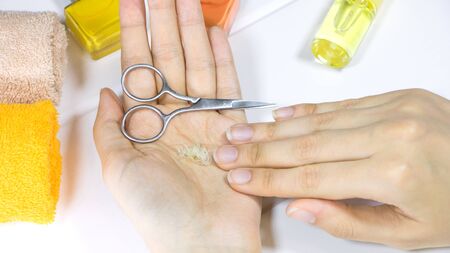 Manicure. A woman holds a cut-off nails in her hand. Cut your fingernails with small nail scissors. Trim your nails. Young woman taking care of her nails. Hygiene, clipping, cutter, self, procedure.の写真素材