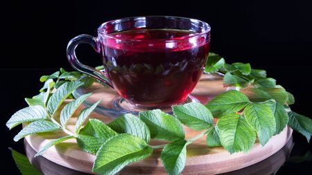Creative layout made of cup of red tea and tea leafs. Tea time: cup of tea, carcade, karkade, rooibos. Oriental, cozy, ceremony, tradition, japanese, leafy, hygge, autumn, 5 o'clock, afternoon teaの写真素材