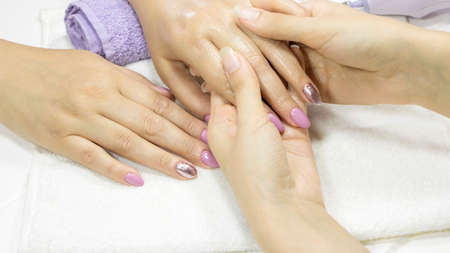 The manicurist applies a moisturizer to the client's hands. Manicure. Hand cream, skin care. SPA,...