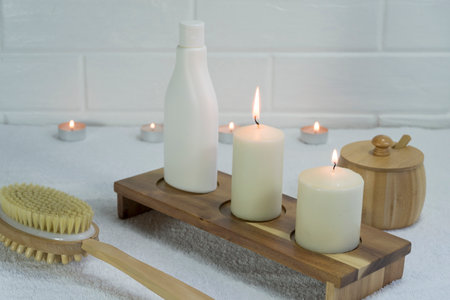 Candles and cream in the SPA. Wooden brush made of natural boar bristles. Massage and relaxation. Home skin care. Beauty treatment. Take care of yourself. Home Spa salon. Beauty concept of quarantine.の写真素材