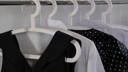 Woman chooses an outfit. Women's clothing hangs on a hanger. Classic style, office, feminine. Buying...