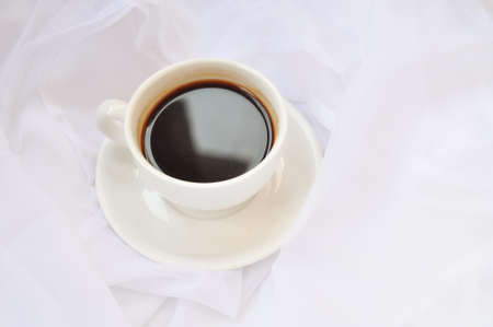 cup of coffee with white roses in the morningの写真素材