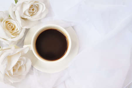 cup of coffee with white roses in the morningの写真素材