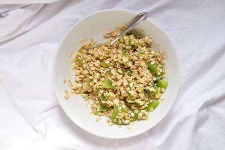 a plate of delicious oatmeal with green kiwi in the morningの写真素材