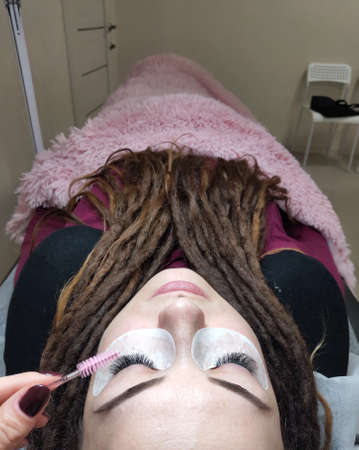 Woman with dreadlocks in beauty salon on lash extensionsの写真素材