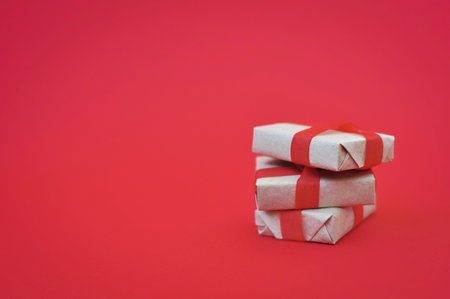 gift in wrapped paper on red background holiday moodの写真素材