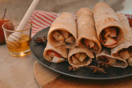 Rolled pancakes with apple cinnamon and honeyの写真素材