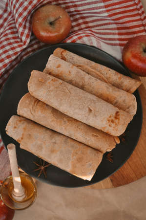 Rolled pancakes with apple cinnamon and honeyの写真素材