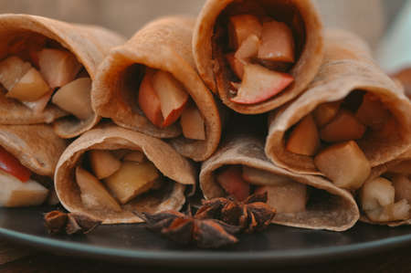 Rolled pancakes with apple cinnamon and honeyの写真素材