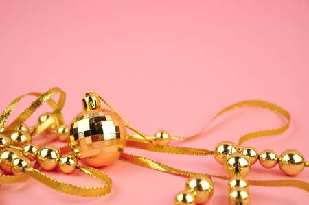 Golden beads on pink background copy spaceの写真素材