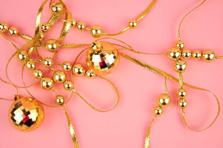Golden beads on pink background copy spaceの写真素材