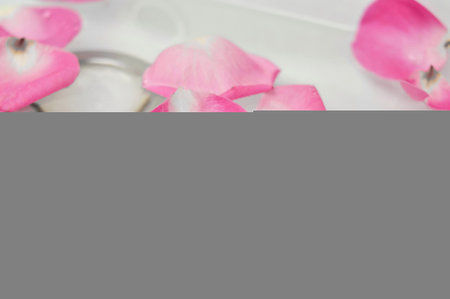 Pink petals of roses in sink in waterの写真素材