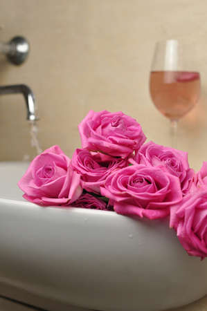 Glass of wine and bouquet of pink roses in sinkの写真素材