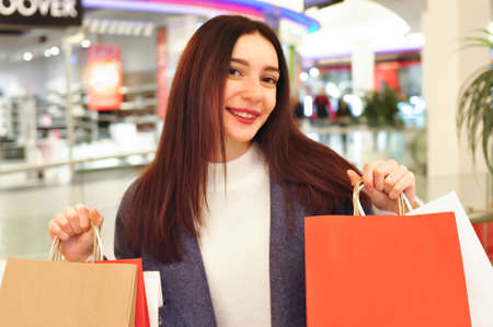 Young brunette woman with gifts and shopping bagsの写真素材