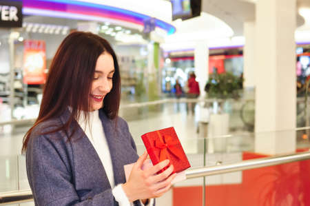 Young brunette woman with gifts and shopping bagsの写真素材