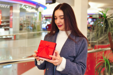 Young brunette woman with gifts and shopping bagsの写真素材