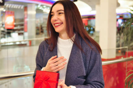 Young brunette woman with gifts and shopping bagsの写真素材
