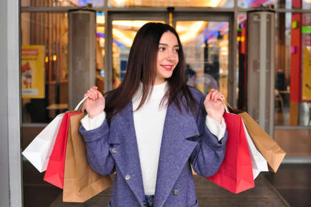 Young brunette woman with gifts and shopping bagsの写真素材