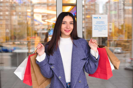 Young brunette woman with gifts and shopping bagsの写真素材