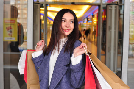 Young brunette woman with gifts and shopping bagsの写真素材