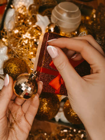 Womans hand holding Golden christmas decorations for tree and homeの写真素材