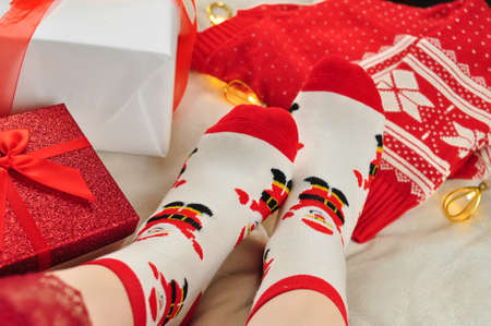 Christmas socks on woman's legs on the bed. High quality photoの写真素材
