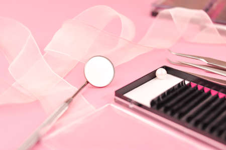Equipment for eyelash extensions on pink background . High quality photo