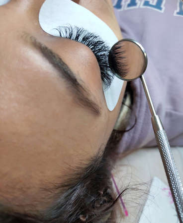 Lash extensions in beauty salon macro eye . High quality photo