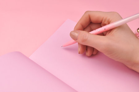 Making notes in pink notebook copy space . High quality photoの写真素材
