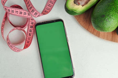 Smartphone with green screen and fresh vegetables copy space. High quality photo