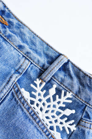 White snowflake in blue jeans pocket . High quality photoの写真素材