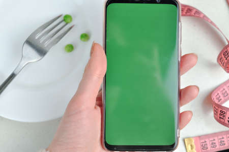 Smartphone with green screen and fresh vegetables copy space. High quality photoの写真素材