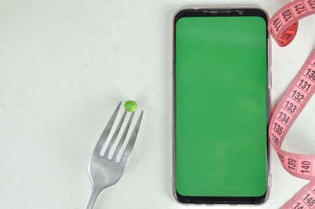 Smartphone with green screen and fresh vegetables copy spaceの写真素材
