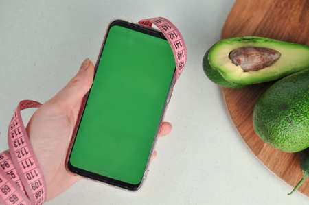 Smartphone with green screen and fresh vegetables copy spaceの写真素材