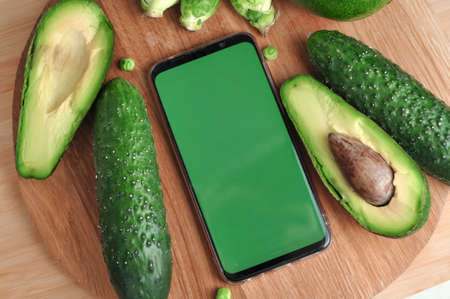 Smartphone with green screen and fresh vegetables copy space. High quality photoの写真素材