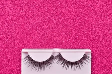 Pink background with false lashes copy space . High quality photoの写真素材