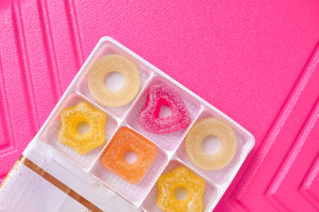 Sweet sugar marmalade different geometric forms on pink background . High quality photoの写真素材