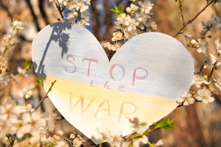 Ukrainian flag from paper heart shape with losung stop the war. Blooming Ukraine symbol