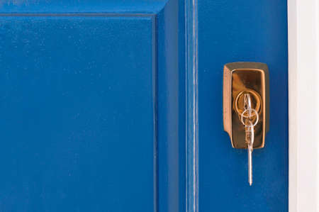 Metal keys in golden lock fro. blue door. High quality photoの写真素材