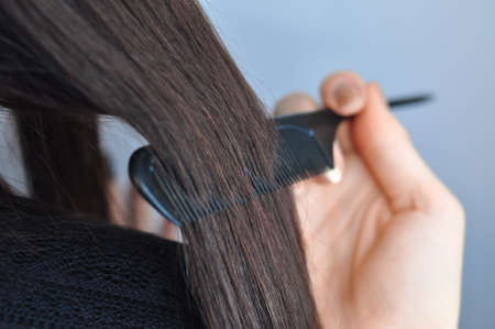 Combing hair with hairbrush macro view copy space . High quality photoの写真素材