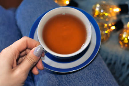 close up of cup of black tea with blue stripes at home ,teatime and relaxの写真素材