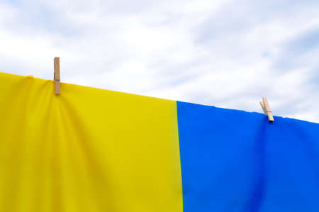Blue and yellow national Ukrainian flag hanging on clothespins close up. High quality photoの写真素材