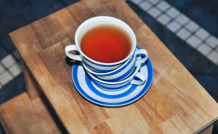 close up of cup of black tea with blue stripes at home ,teatime and relaxの写真素材